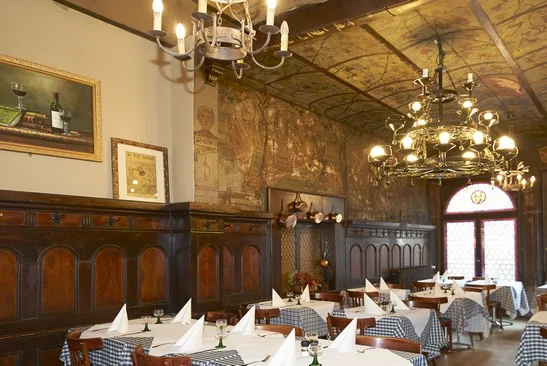 La salle classée : boiseries sombres, lustres en fer forgé et murs peints